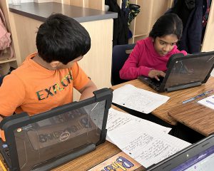 Two students work on computers