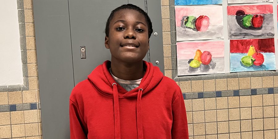 student in red shirt poses