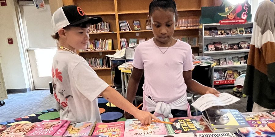 Students pick out a book in the library