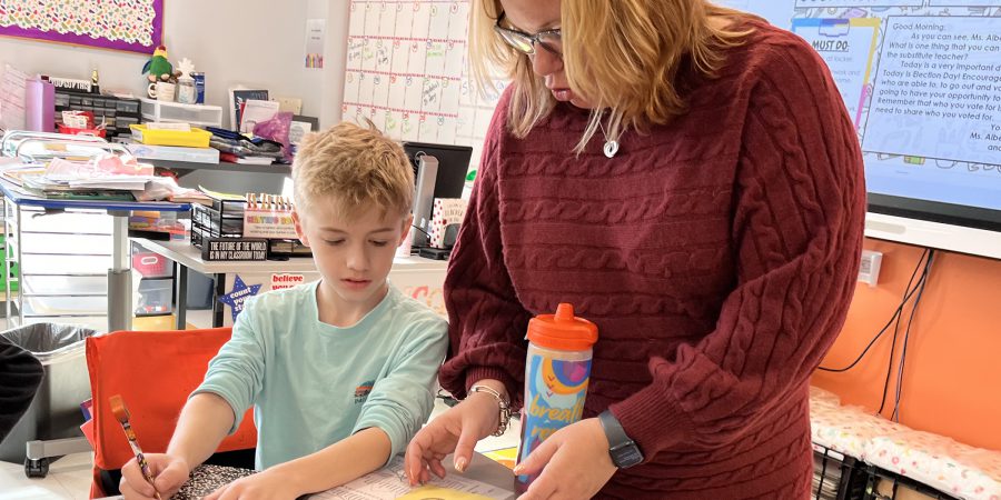 Superintendent looks at a document with a 5th grade student