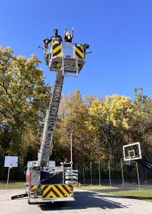 Principal and firefighter drop an egg from a fire truck bucket