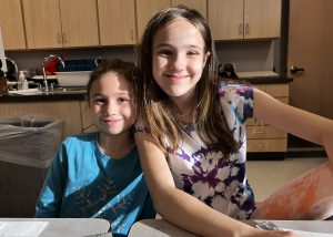 two female students post while smiling