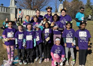 Group shot of Girls on the Run members and their advisors wearing purple shirts