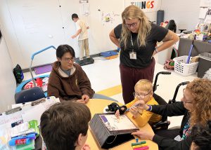 college students and physical therapist with a student in a wheel chair