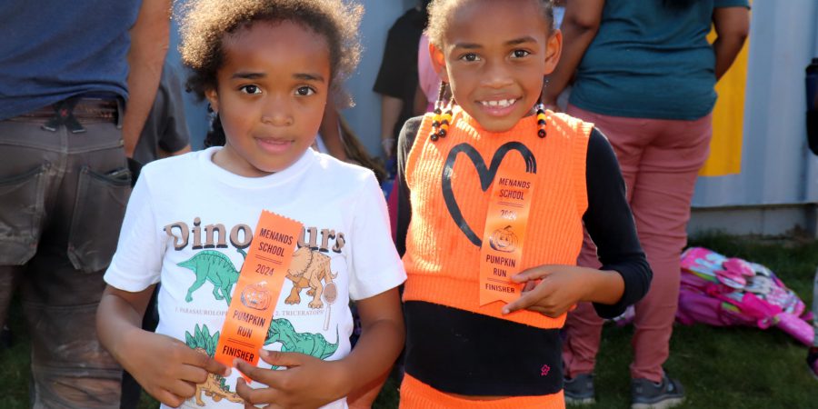 Runners smile while holding their ribbons