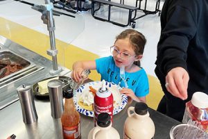 Student making a pancake topping