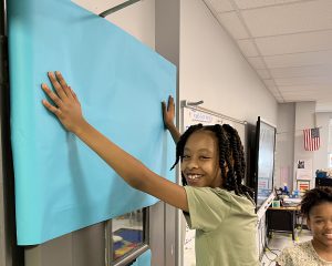 Student smiling while decorating a door