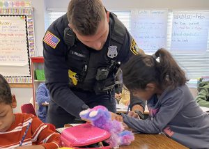 A police officer helps a student in the classroom