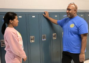 Taj Buskey talks with a student in the hallway